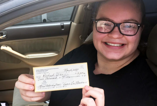 Racheal Diaz, SDHS senior, smiling displays her scholarship check.